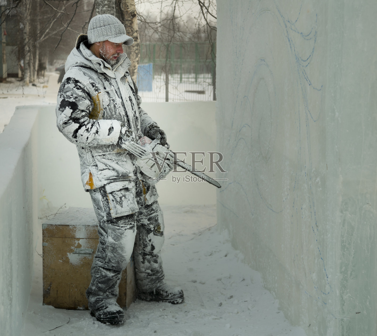 这位雕刻家用一把汽油锯从冰块上雕刻出一个雕像照片摄影图片