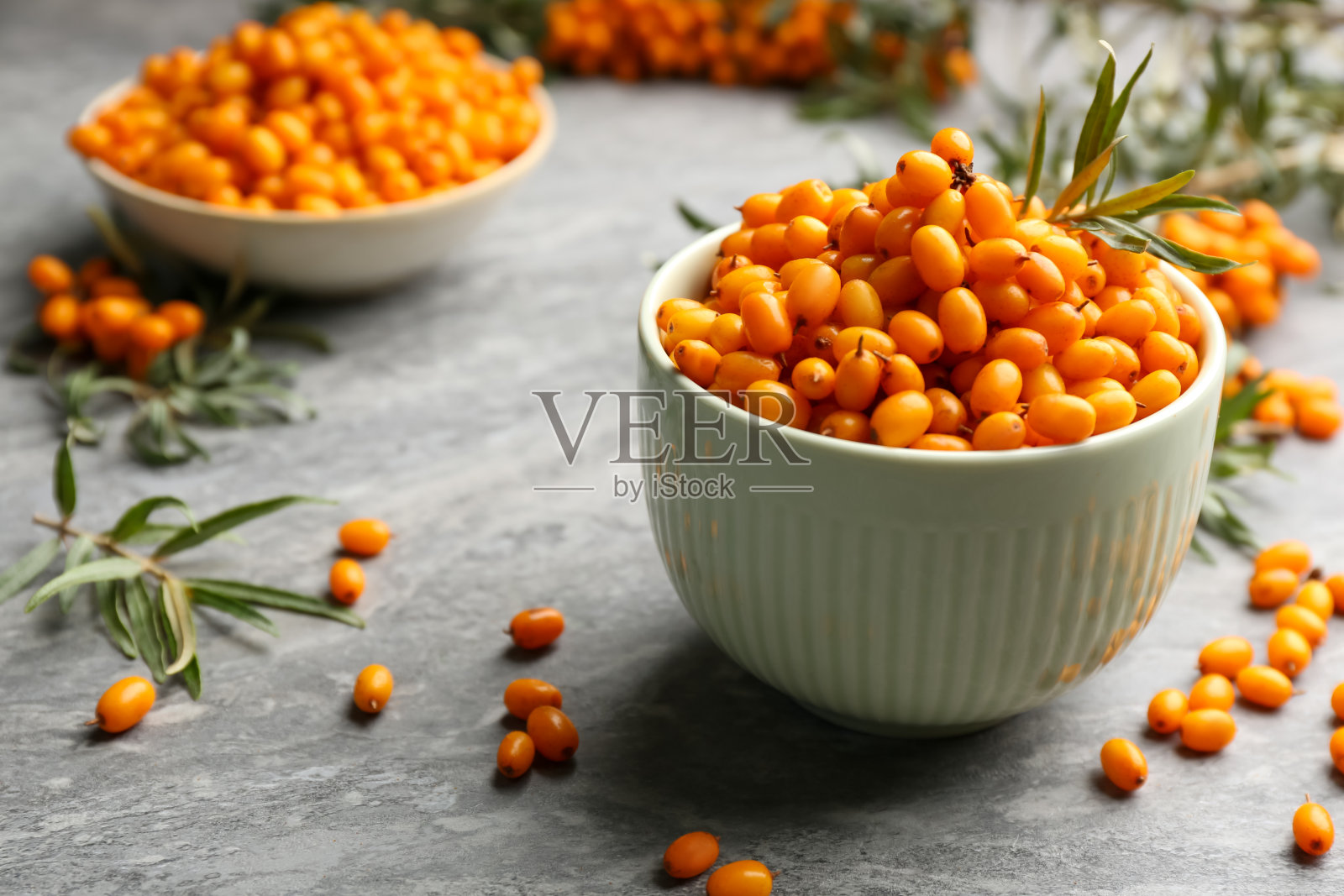 鲜熟沙棘碗放在灰桌上照片摄影图片
