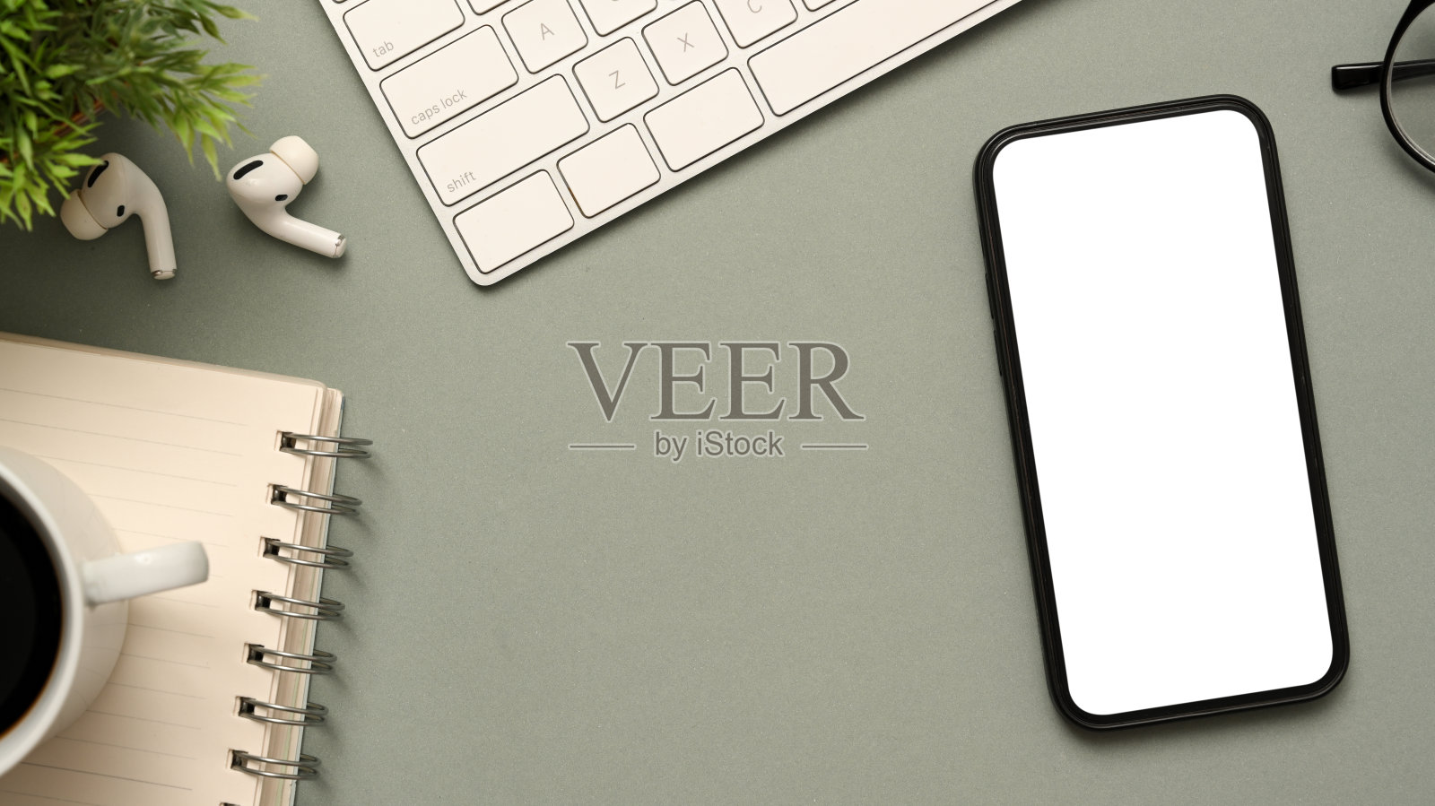 现代工作场所的桌面顶视图与智能手机模型在灰色背景。照片摄影图片