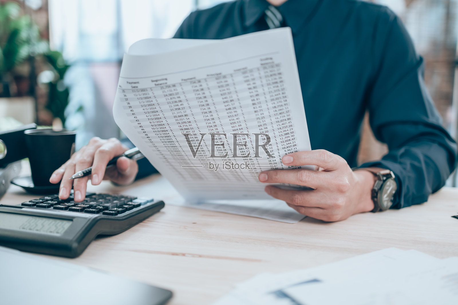 会计阅读并使用计算器计算公司数据、文件和报表。会计业务的概念。照片摄影图片