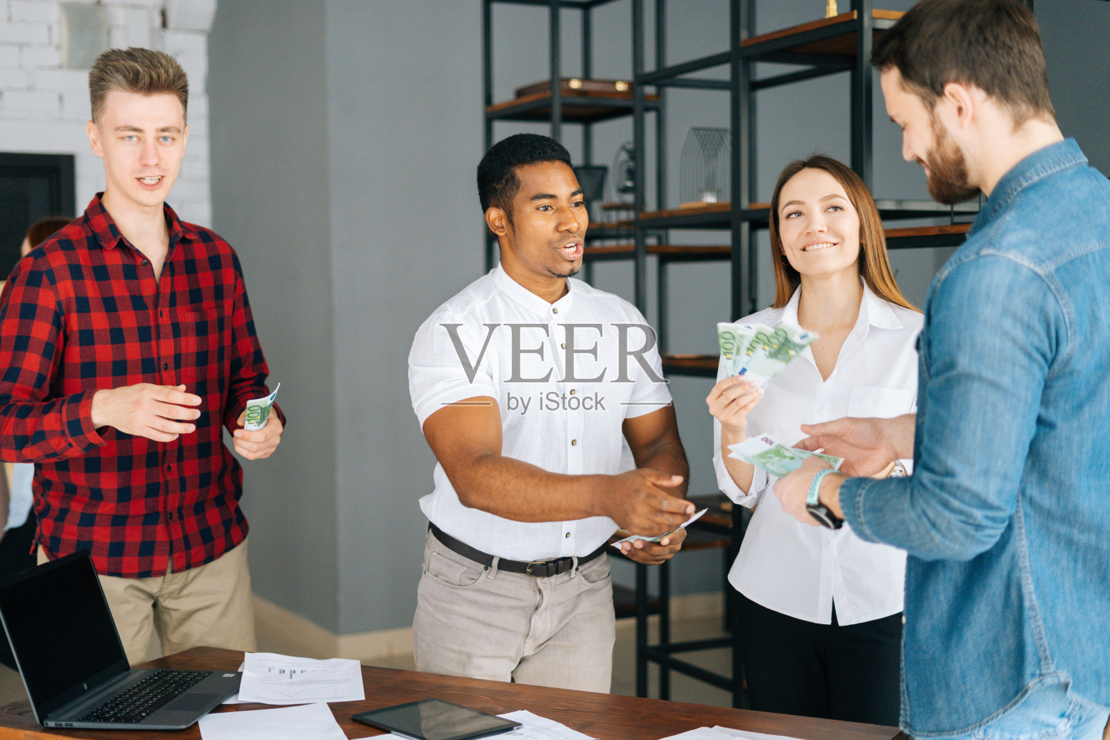 非裔美国男性经理给快乐的员工现金工资。金钱雨的概念。照片摄影图片