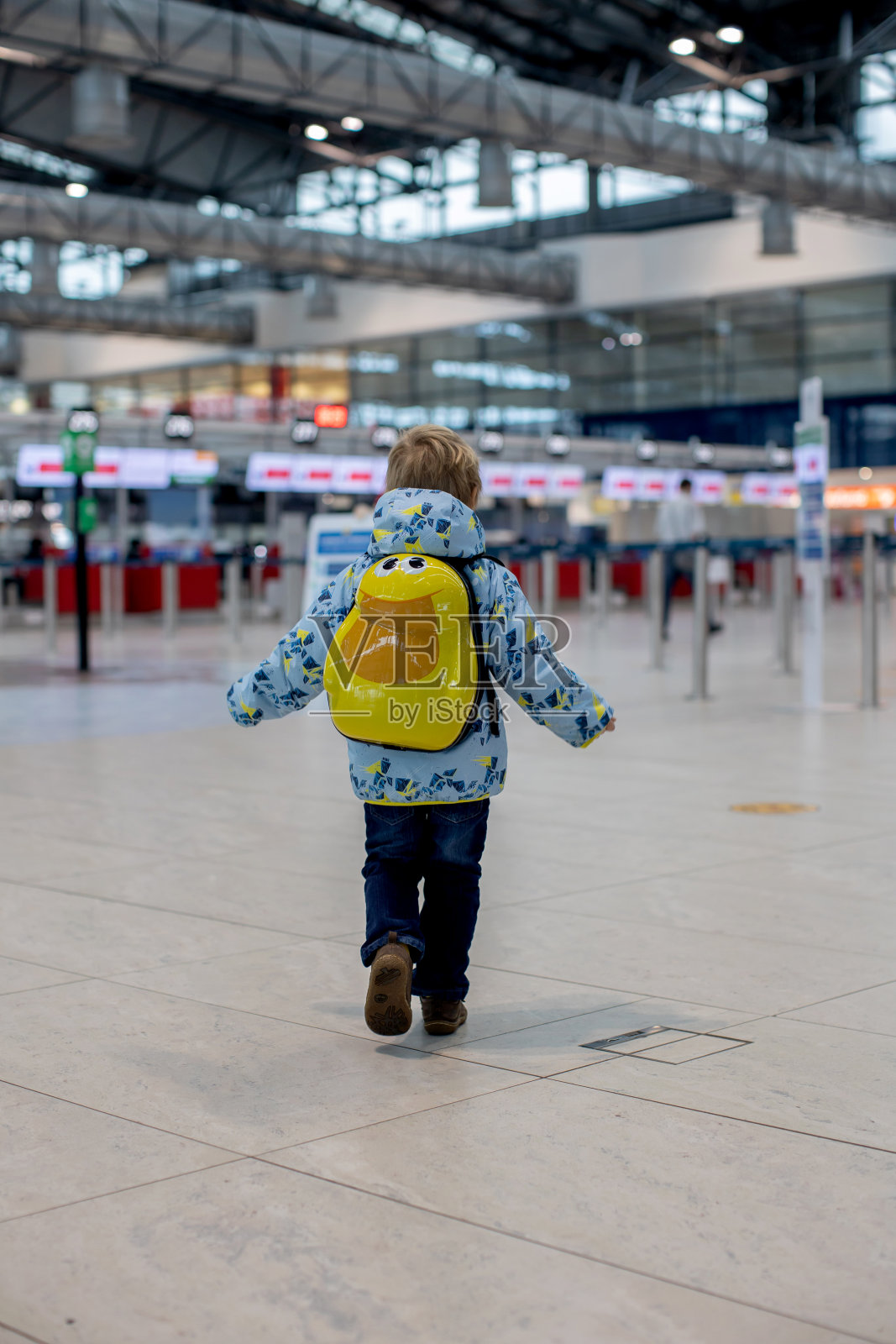 可爱的小男孩在机场登机口附近的中转大厅等待登机。积极的家庭生活方式与孩子乘飞机旅行照片摄影图片