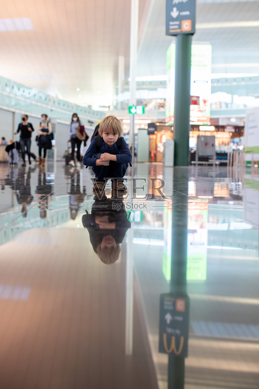 可爱的小男孩在机场登机口附近的中转大厅等待登机。积极的家庭生活方式与孩子乘飞机旅行照片摄影图片