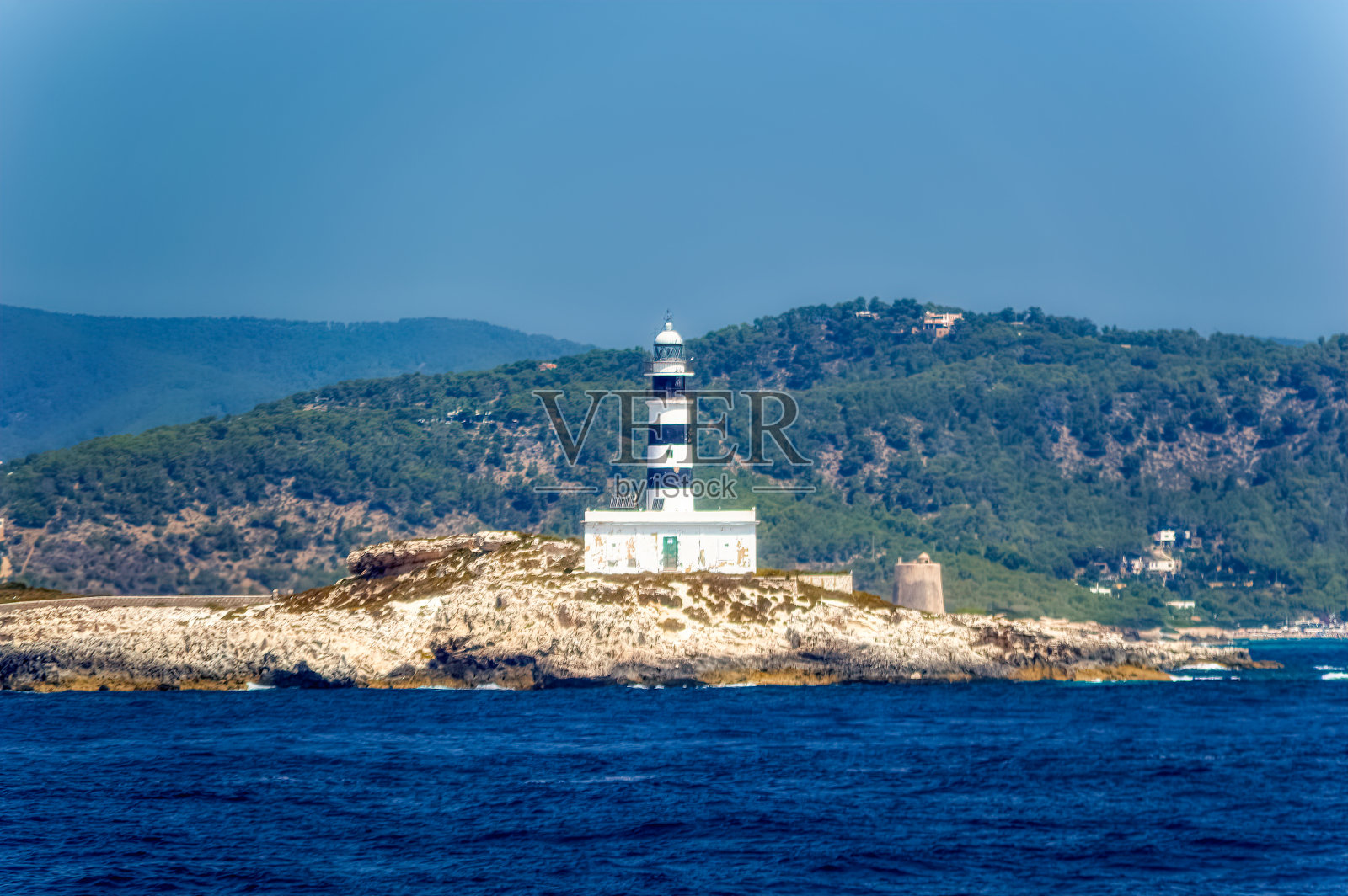 俯瞰位于西班牙伊比沙岛附近小岛上的灯塔。照片摄影图片