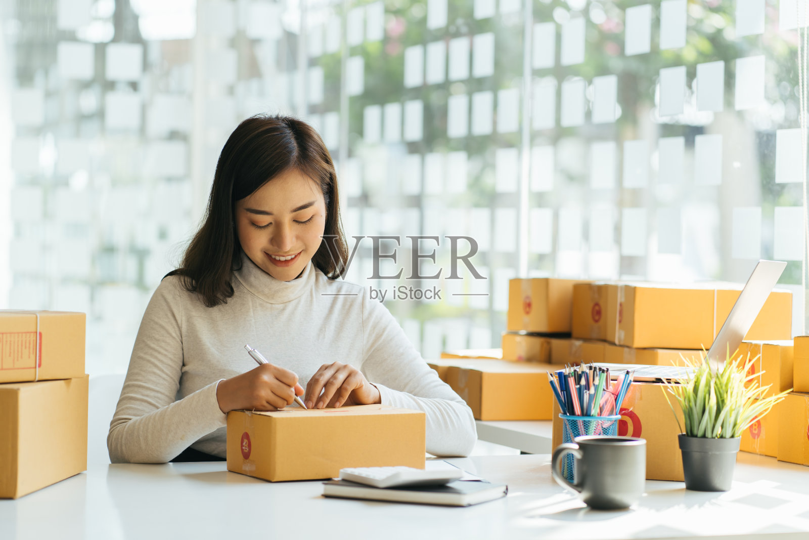 网上卖家所有者。在线购物。创业中小企业的理念。年轻的创业家,小企业主,在家工作,包装和配送情况。照片摄影图片