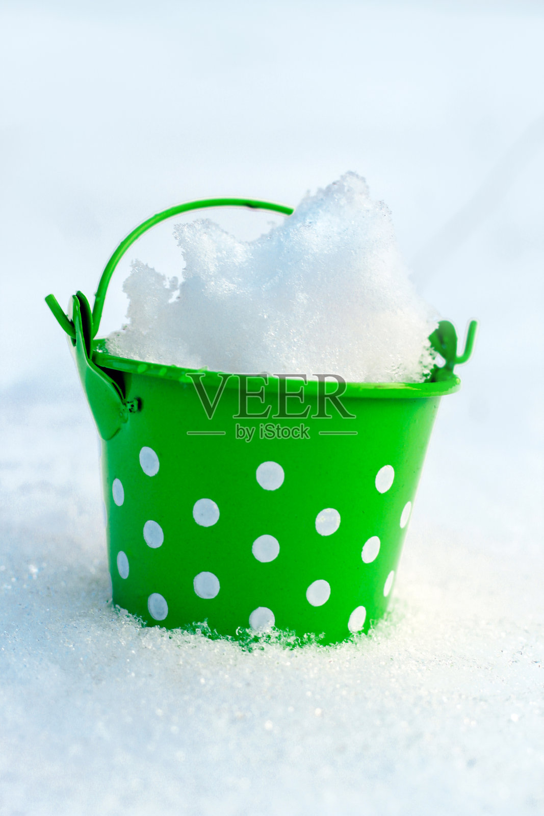 绿色铁小桶在雪的背景照片摄影图片