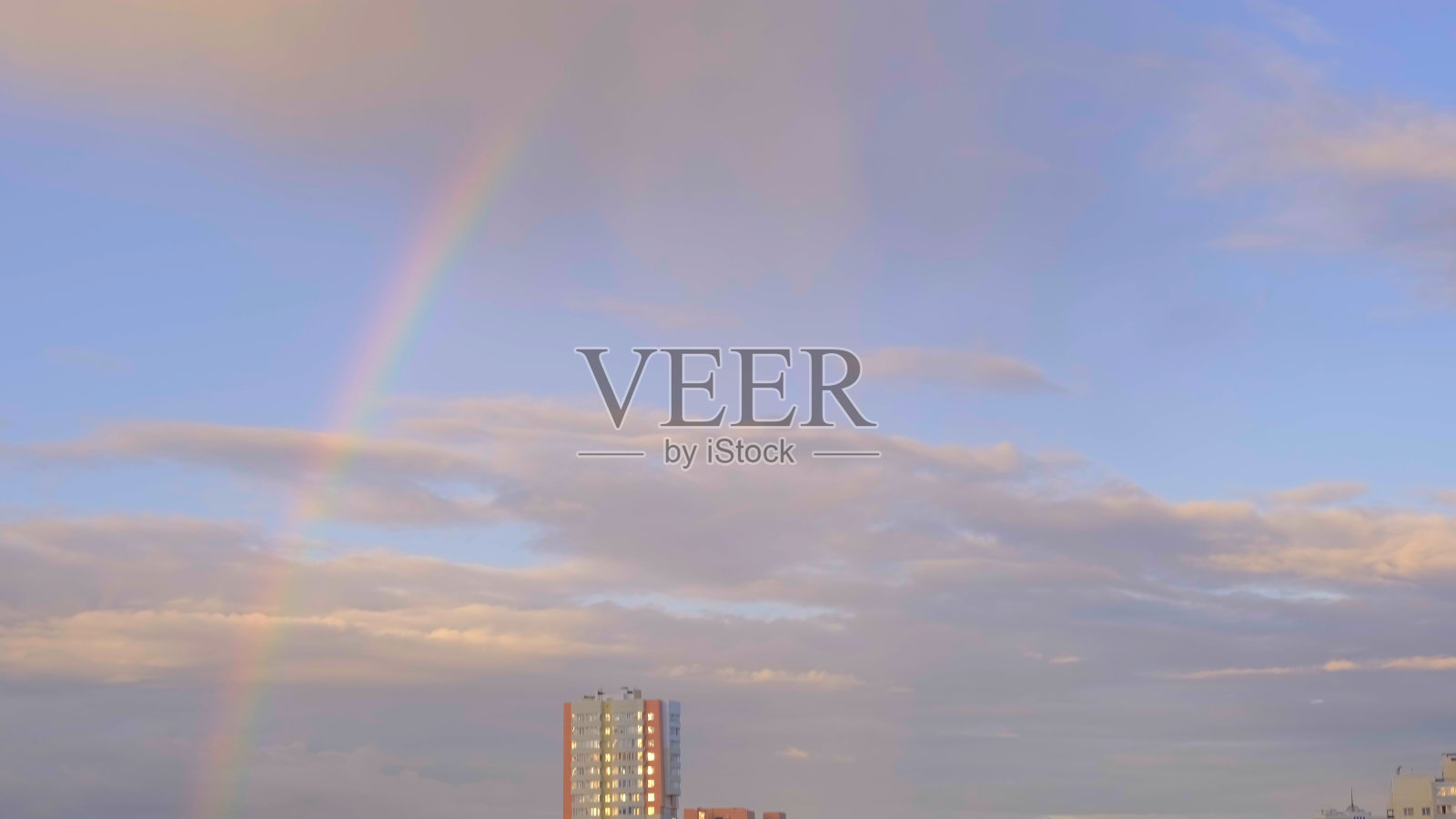 雨后天空中五彩缤纷的彩虹和云朵,城市中的多层建筑,抽象化,模糊化照片摄影图片