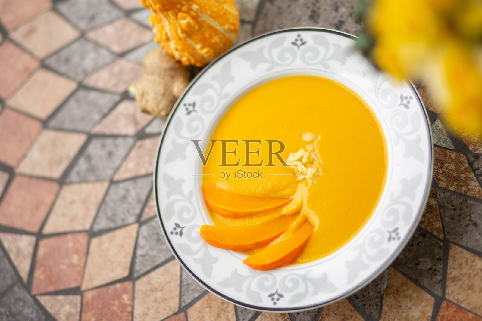 南瓜汤配南瓜片,美味的浓汤。南瓜汤在花园里的桌子上照片摄影图片