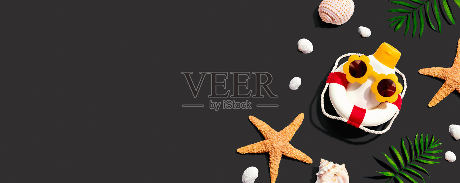 戴着海星和贝壳太阳镜的防晒霜瓶子照片摄影图片