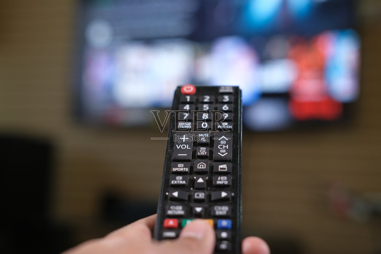 男子手持电视遥控器的特写。照片摄影图片