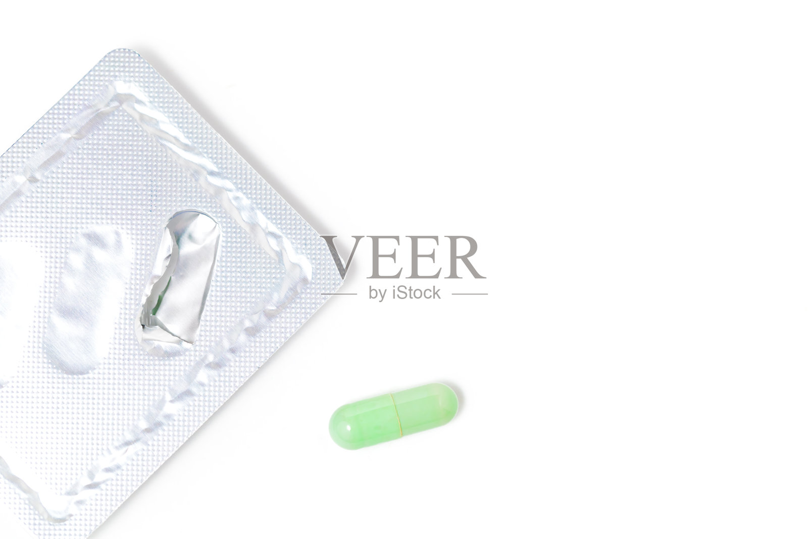 在白色的背景上,绿色的chiretta草本胶囊照片摄影图片