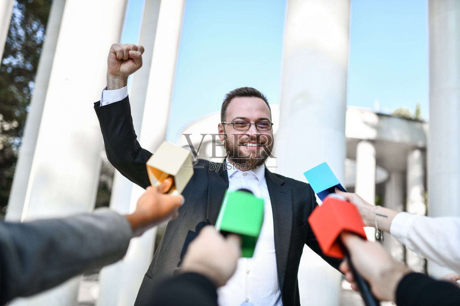 英俊的男性政治家在新闻发布会上为自己的竞选欢呼照片摄影图片