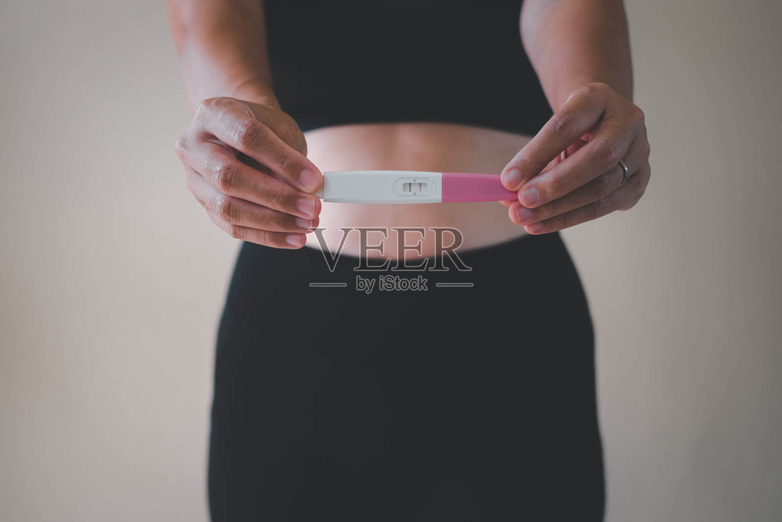 近距离的手显示怀孕测试与两个条纹。积极的结果。重点在验孕试纸上。6周。复古的基调。照片摄影图片