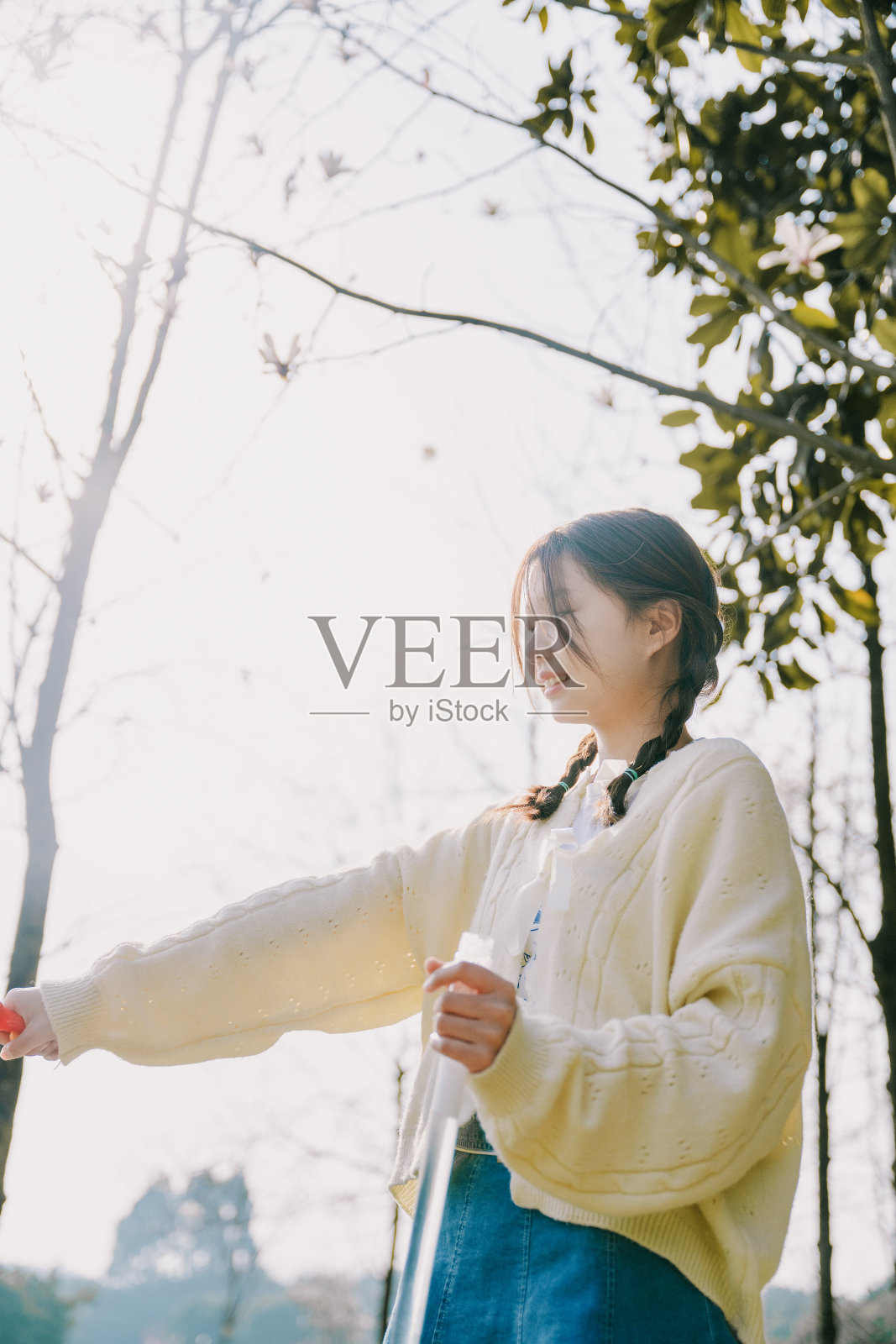 在阳光下玩泡泡的亚洲美女照片摄影图片