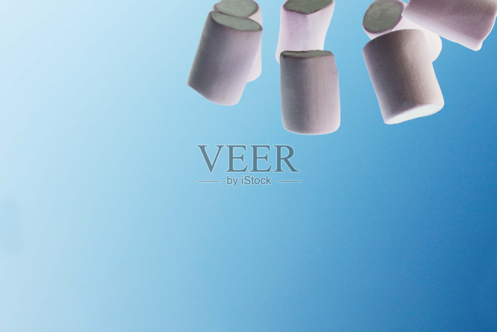 几片粉红色的棉花糖在蓝天和白云的背景上照片摄影图片