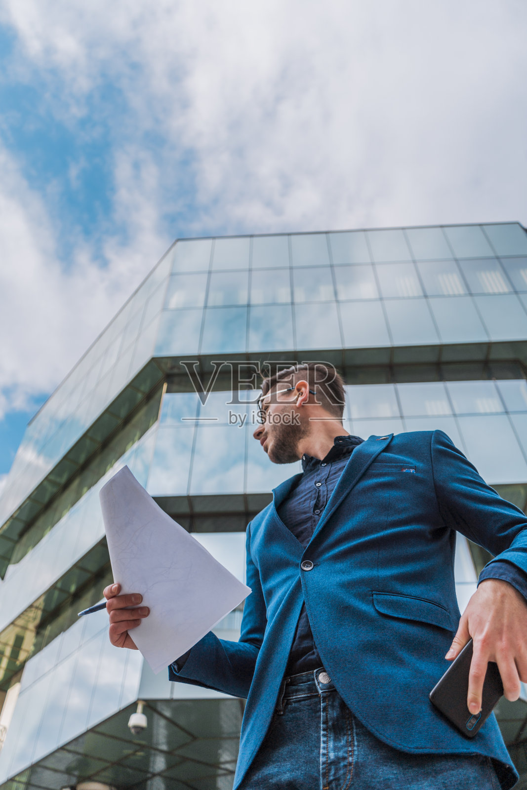 年轻的商人在写商业文件。男办公室经理手持文件的特写照片摄影图片