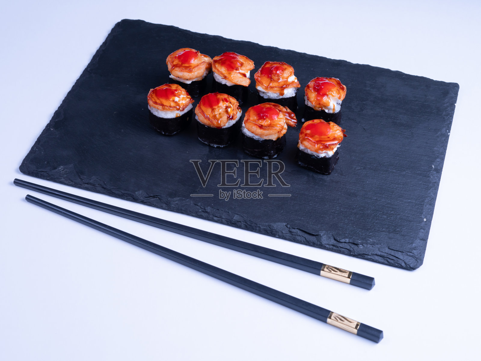 黑色背景的虾手握寿司和酱汁寿司。日本美食寿司卷特写。照片摄影图片