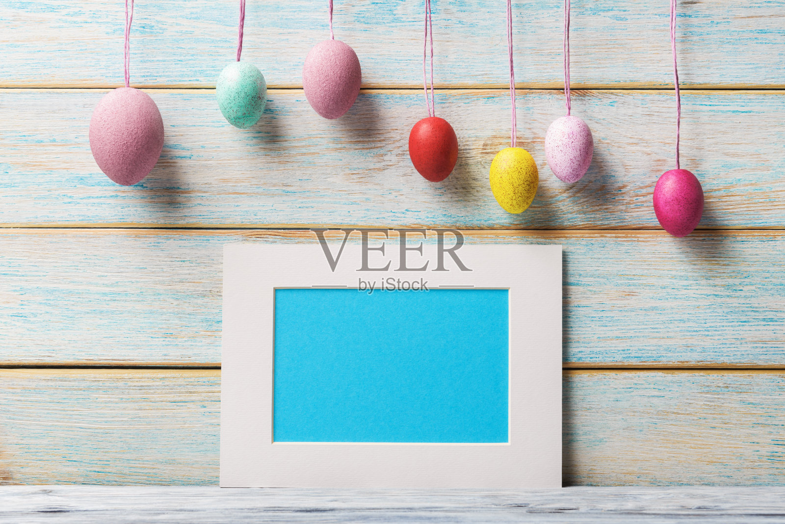 彩色鸡蛋和模拟空白框架与复制空间在轻木制背景。复活节的背景照片摄影图片