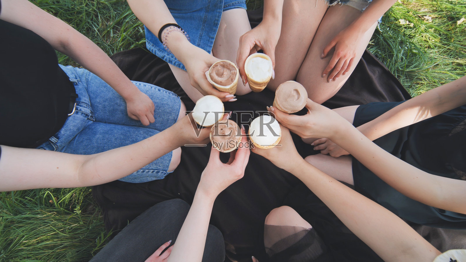 女生们用华夫饼杯里的冰淇淋手拉着手围成一个圈照片摄影图片