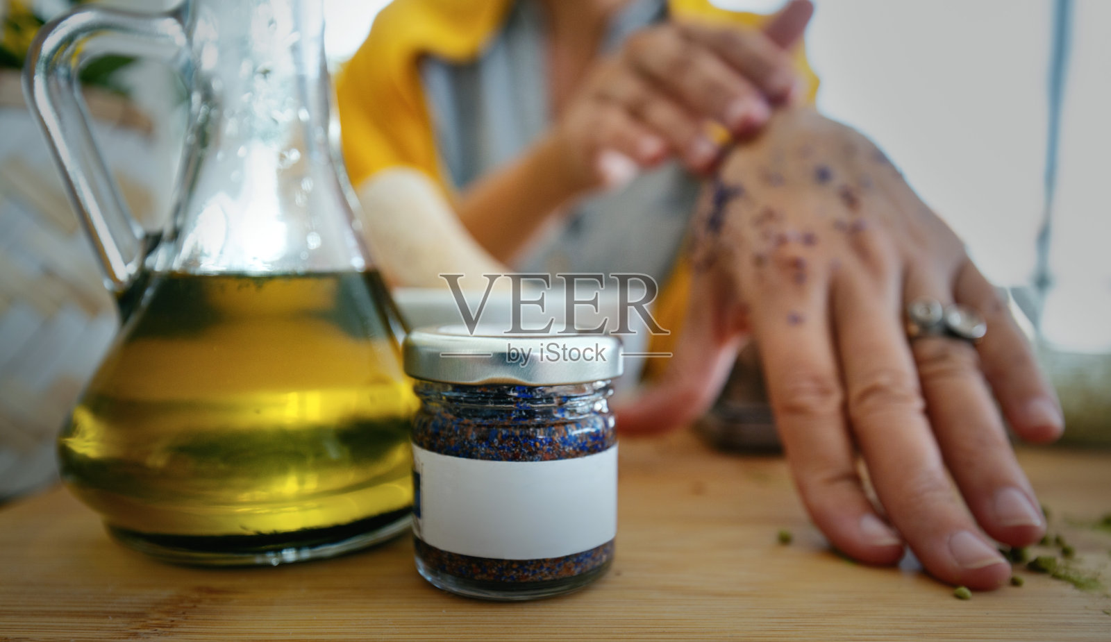 不认识的女人在用手磨砂膏。照片摄影图片