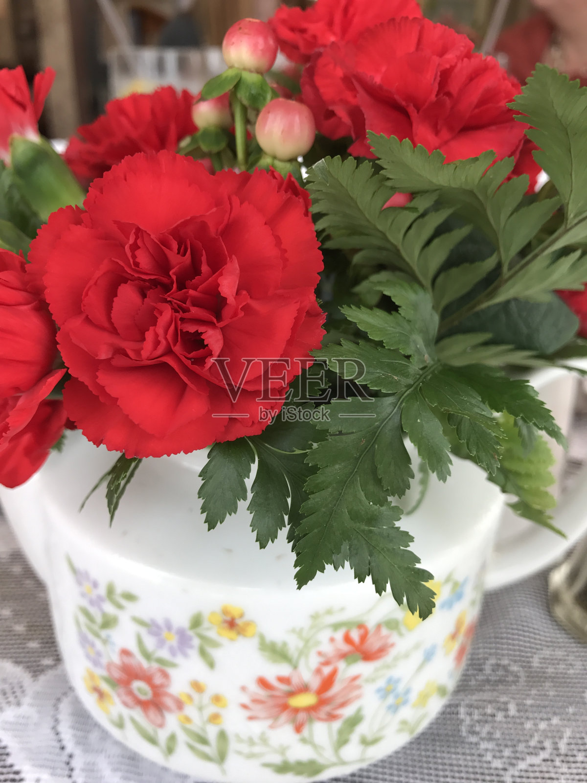 康乃馨在茶壶照片摄影图片