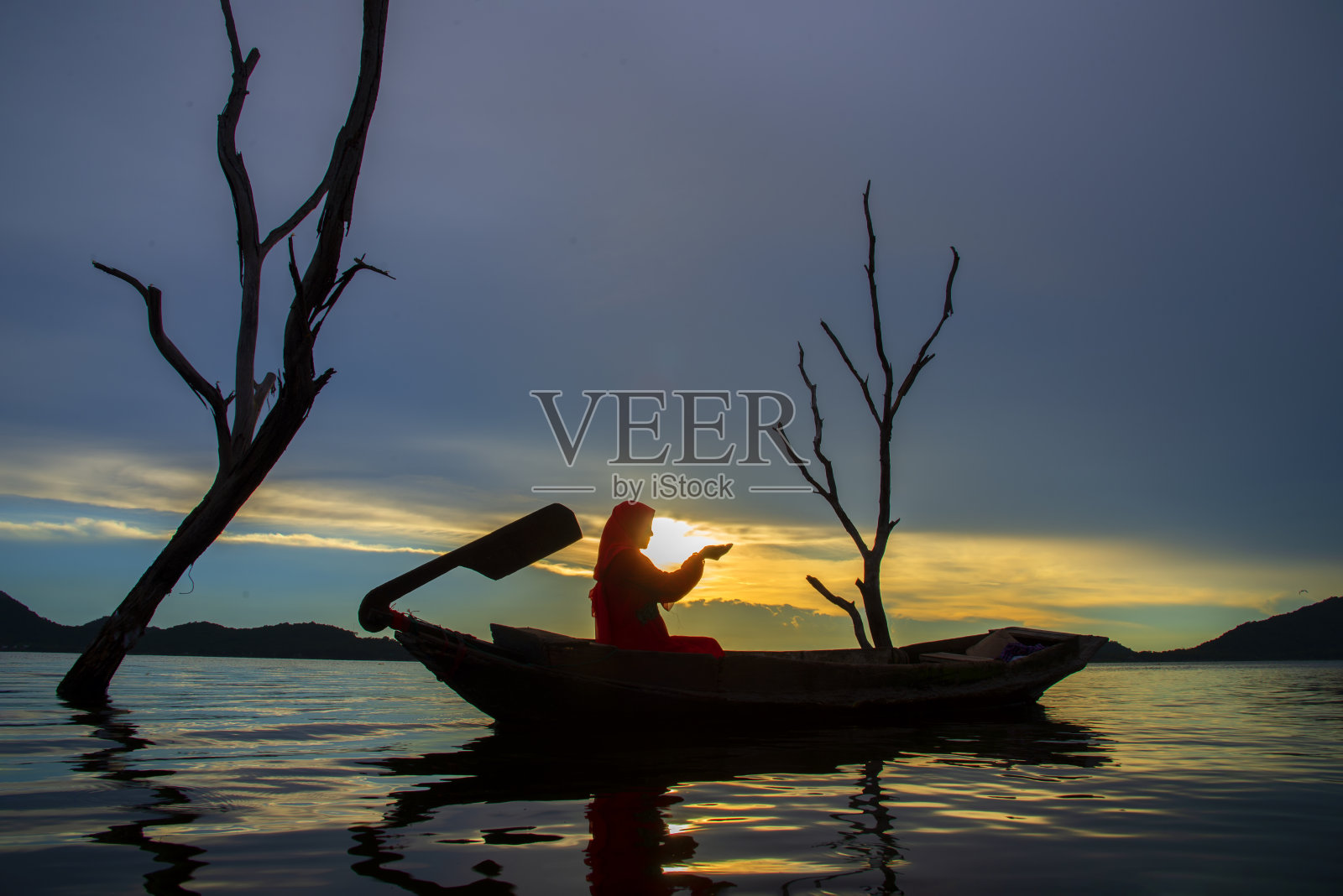 亚洲穆斯林妇女在面纱站和祈祷与天房景观和日落场景的背景。宗教概念伊斯兰教照片摄影图片