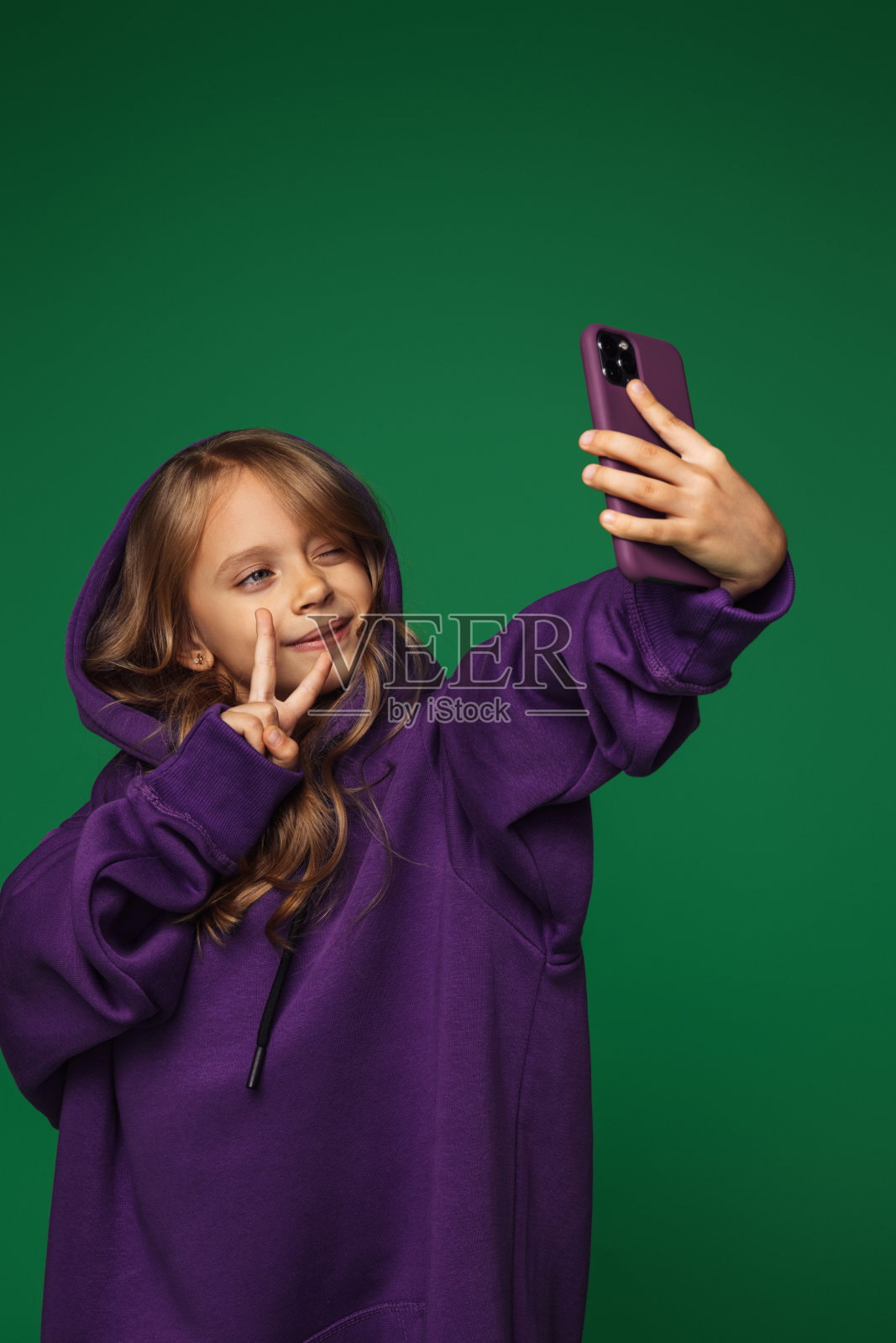 可爱的蓝眼睛女孩在用手机照片摄影图片