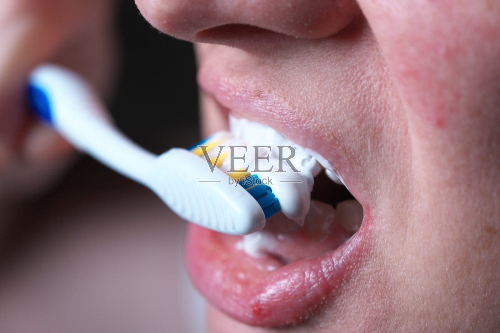 刷牙。特写镜头:牙刷在人嘴里摩擦牙齿照片摄影图片