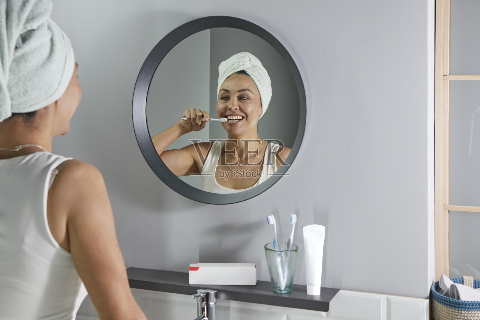 中年妇女刷牙时的倒影照片摄影图片