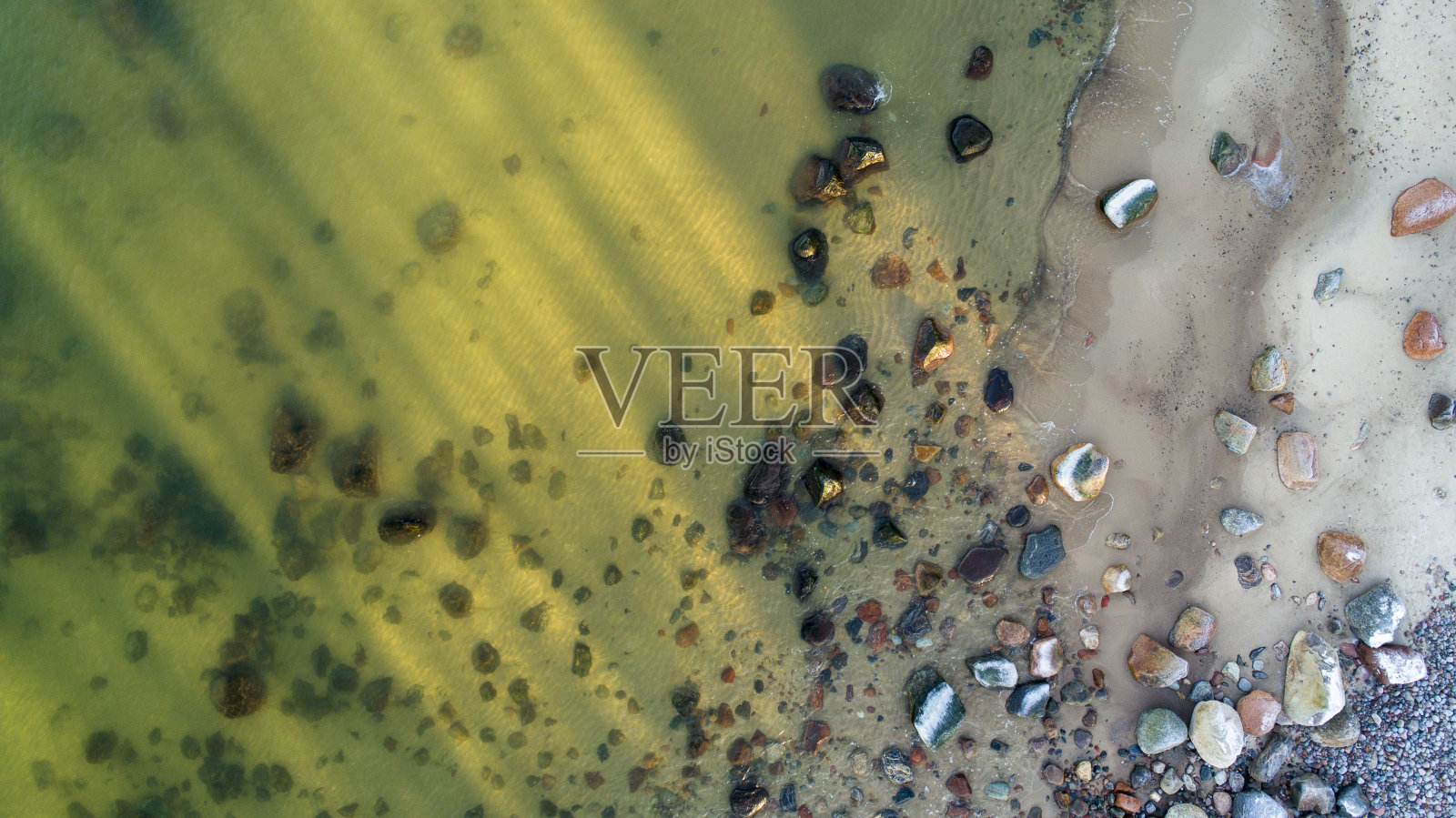 冬天的波罗的海海滩上,阳光照亮了平静、清澈、透明的海水。照片摄影图片