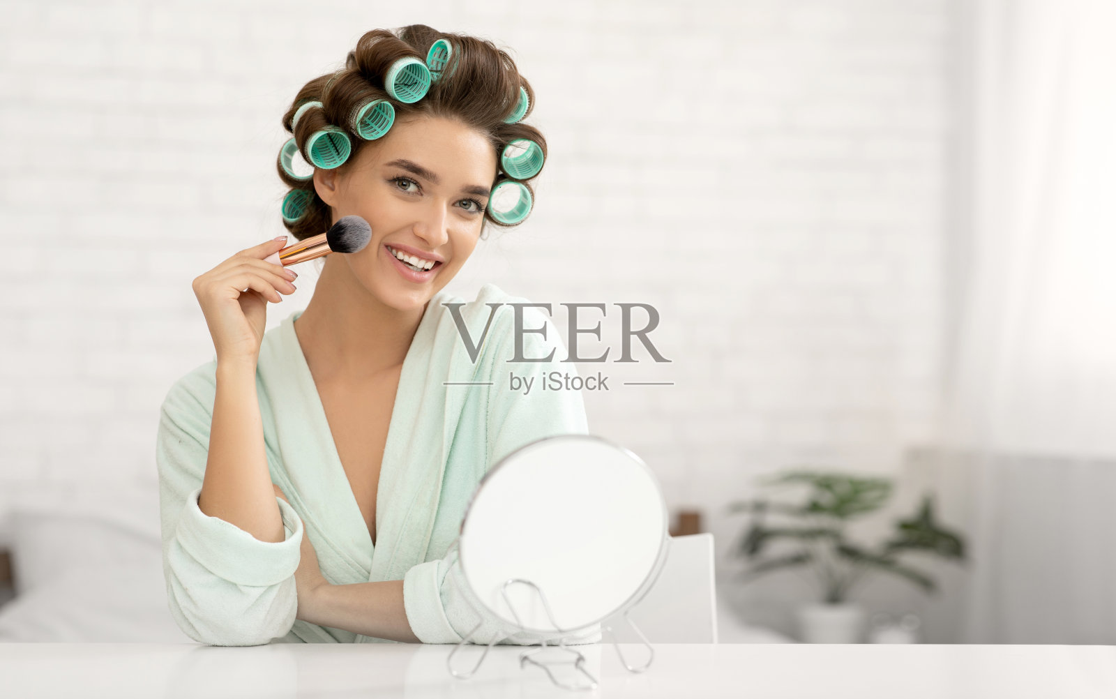 迷人的女士用化妆刷坐在卧室里化妆照片摄影图片