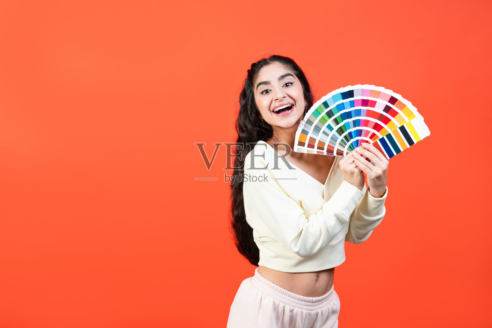 欢快的女人与色彩调色板乐趣与复制空间的橙色背景。照片摄影图片