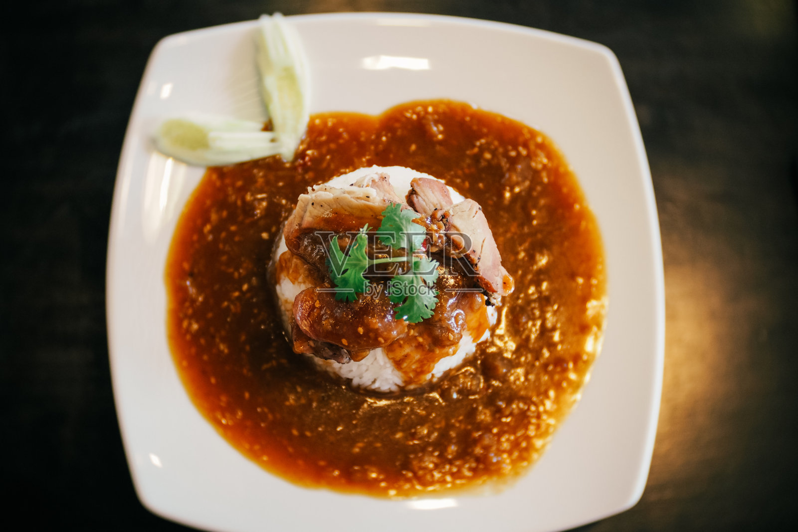 一盘中式叉烧米饭配肉汁。照片摄影图片