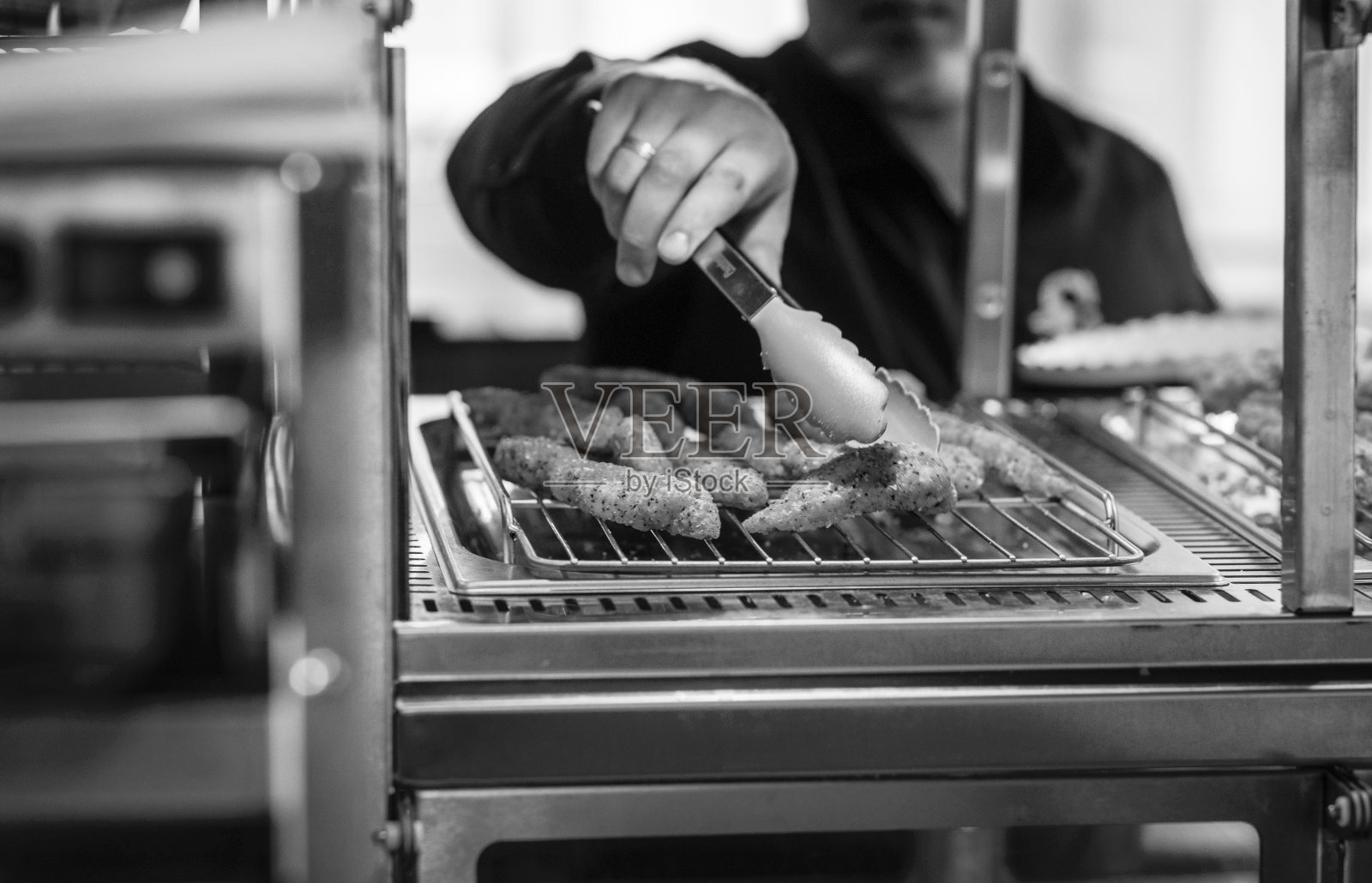 厨师的手拿着酥脆的鸡块在餐厅里的特写镜头照片摄影图片