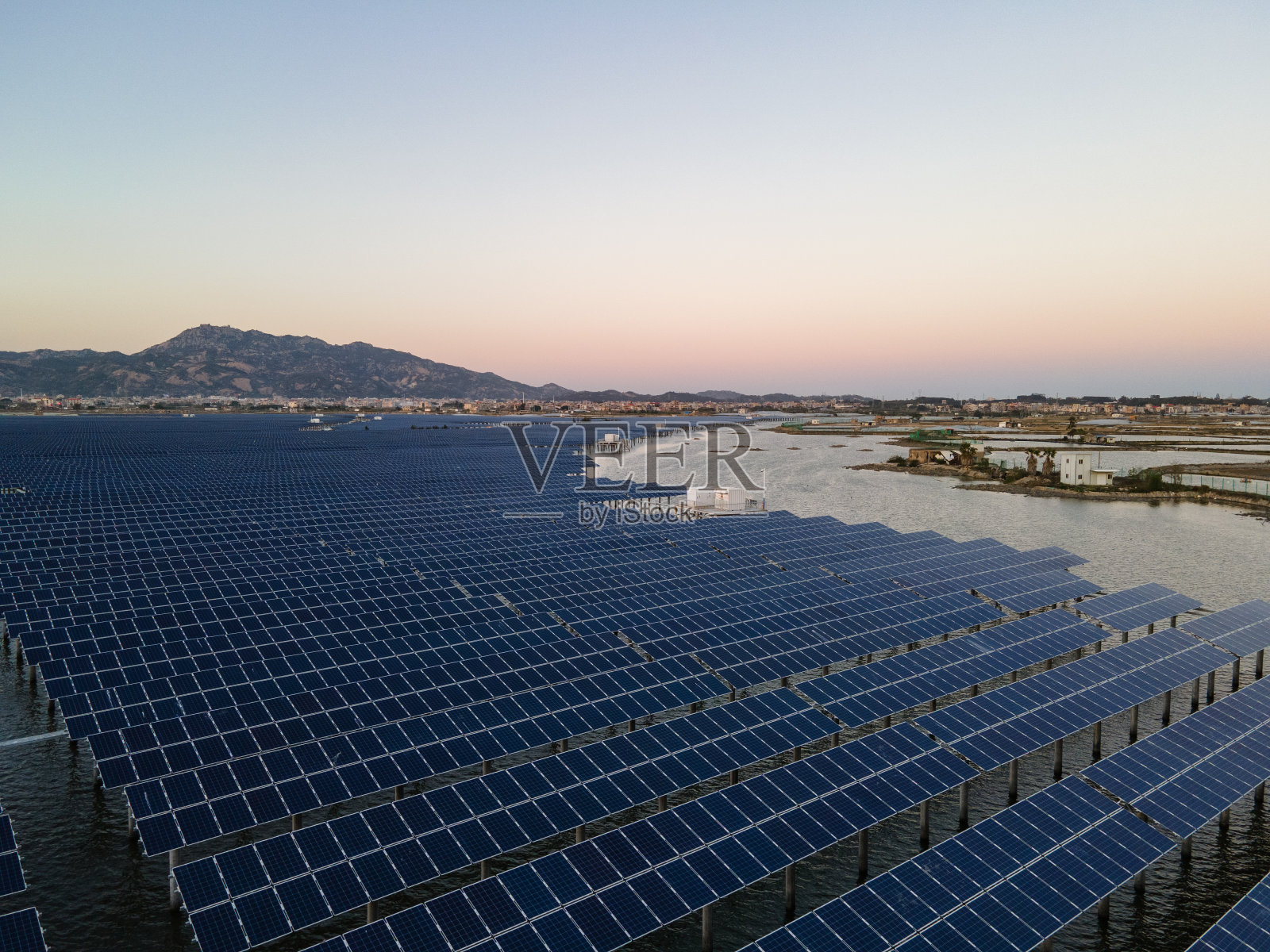 日落时海上太阳能发电厂的鸟瞰图。照片摄影图片