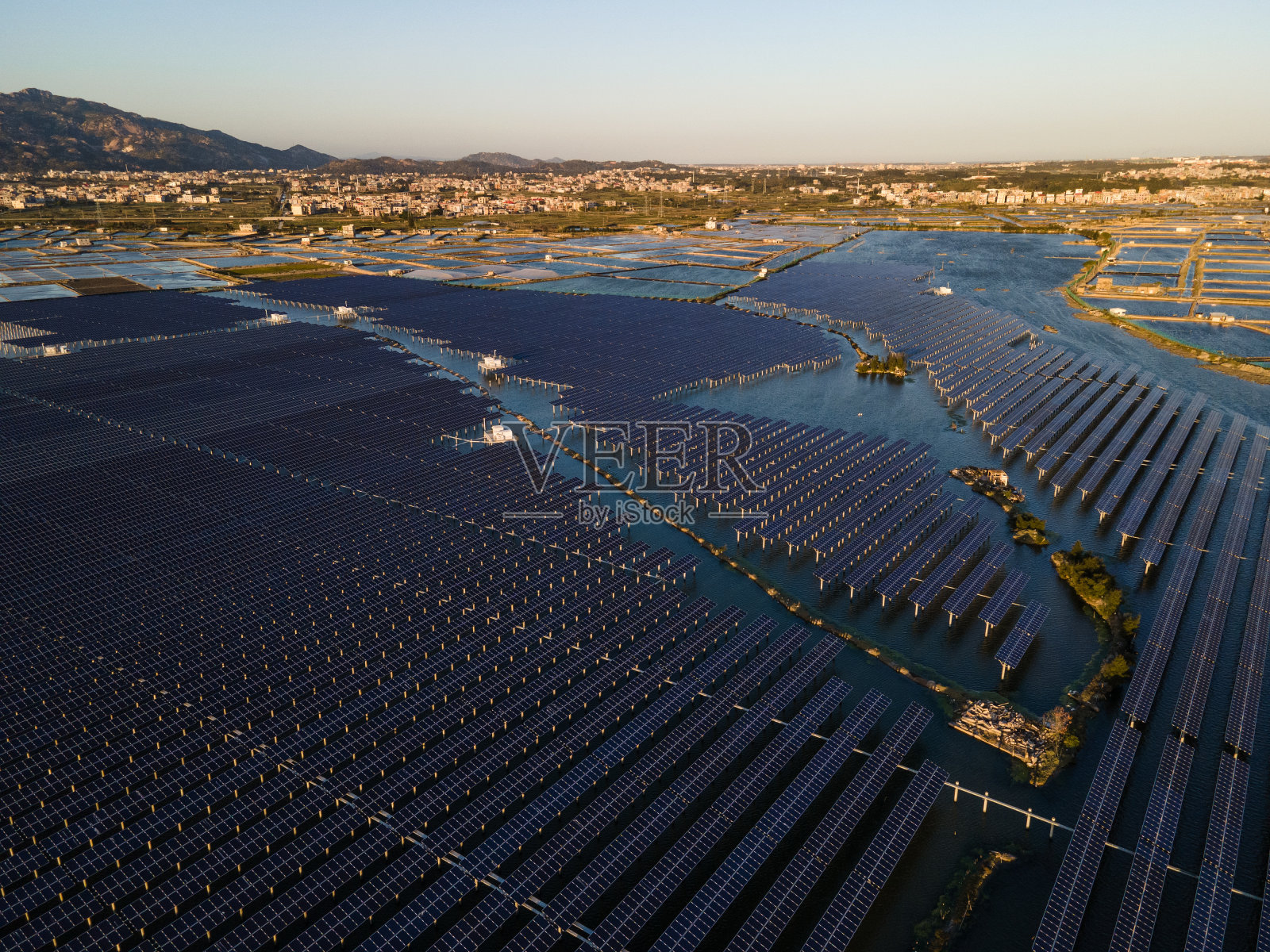 日落时海上太阳能发电厂的鸟瞰图。照片摄影图片