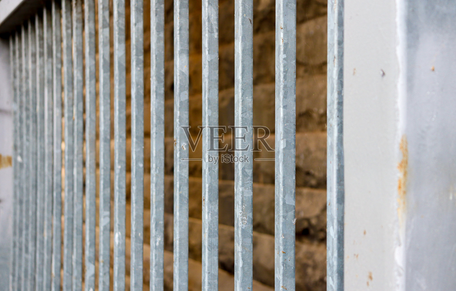 背景为金属栅栏和古老的青石墙照片摄影图片