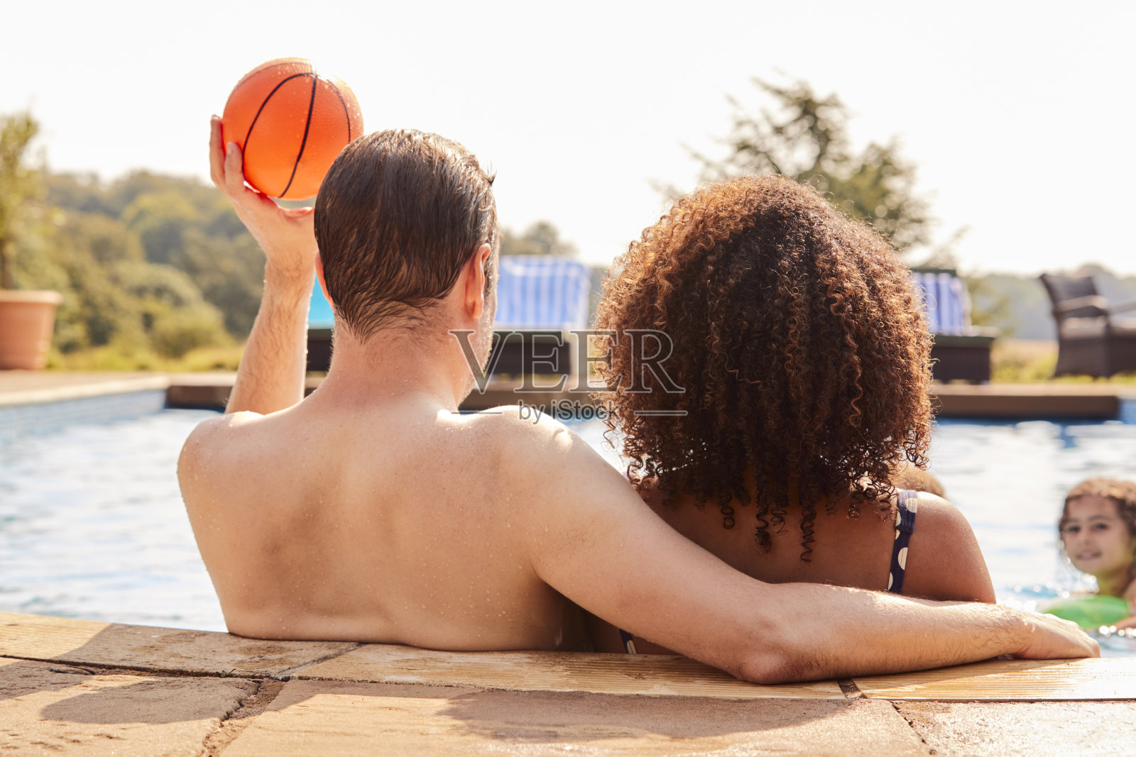 暑假里,爸爸和十几岁的儿子在游泳池里玩得很开心照片摄影图片