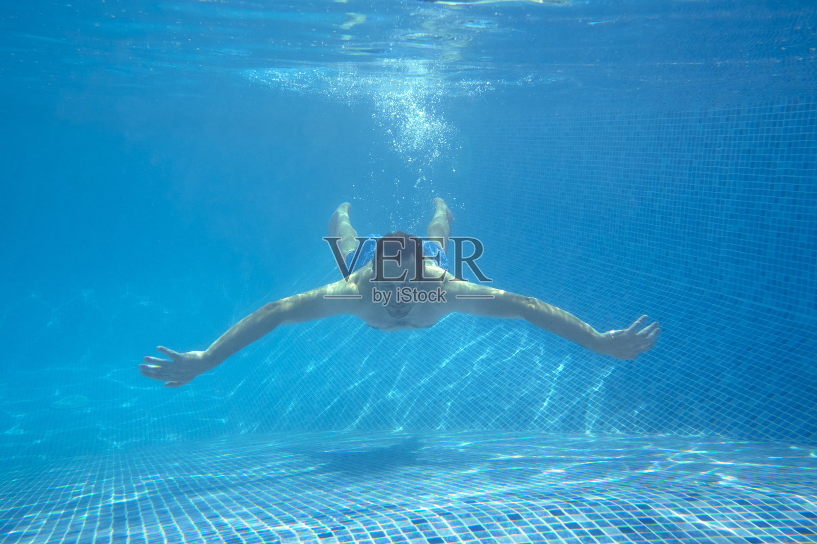 男子在游泳池游泳的水下视图在暑假照片摄影图片