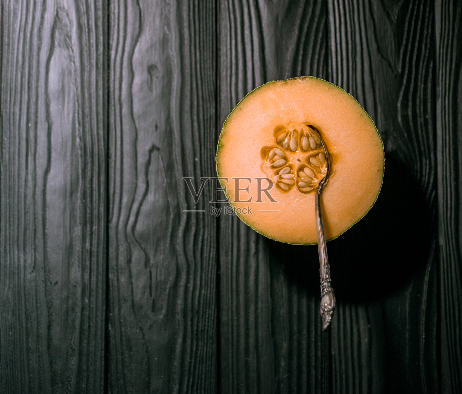 甜瓜上黑黑的底色,小巧可口漂亮的甜瓜,既有整块的,也有碎块的,折起来吃照片摄影图片