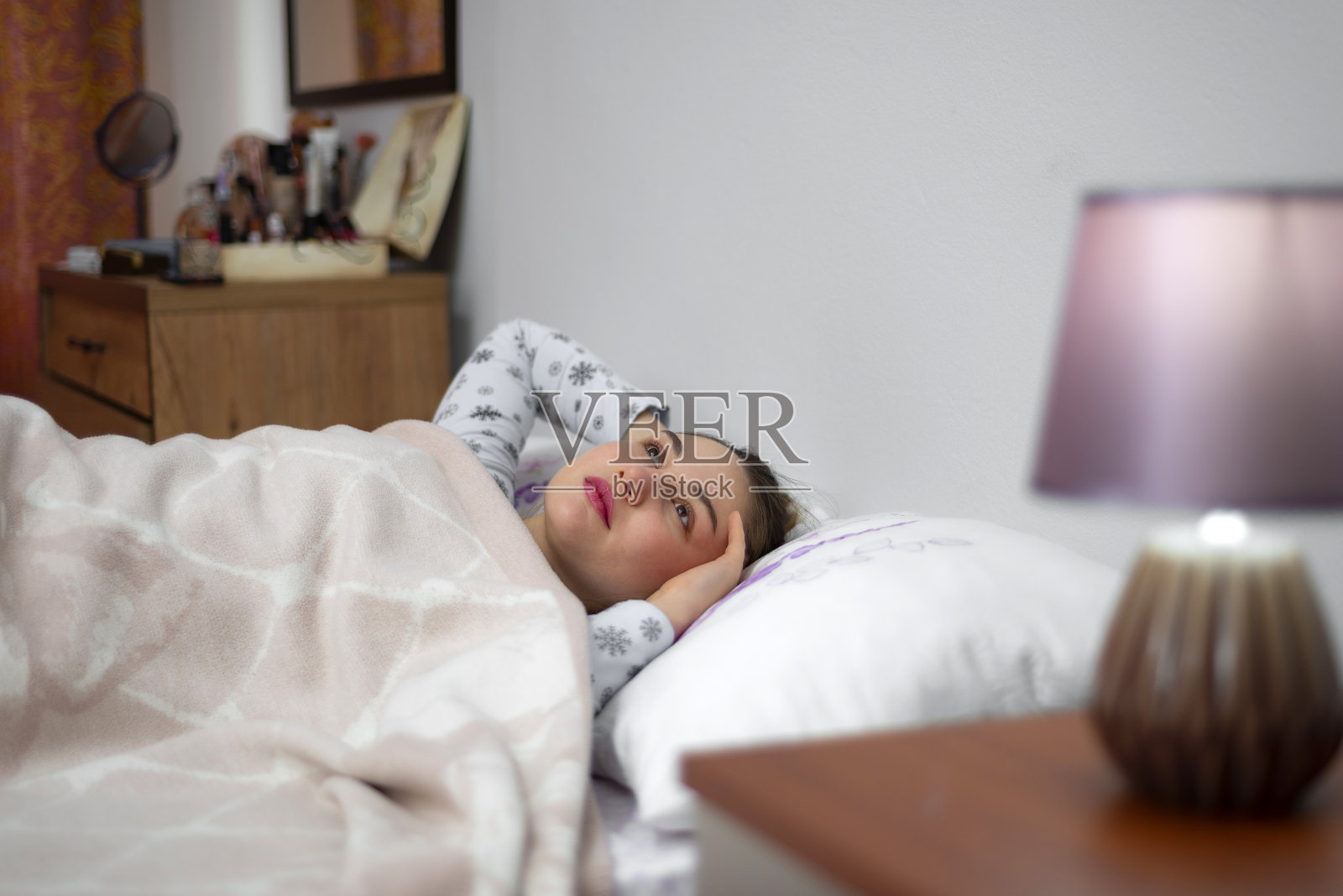 悲伤的年轻女孩躺在床上照片摄影图片