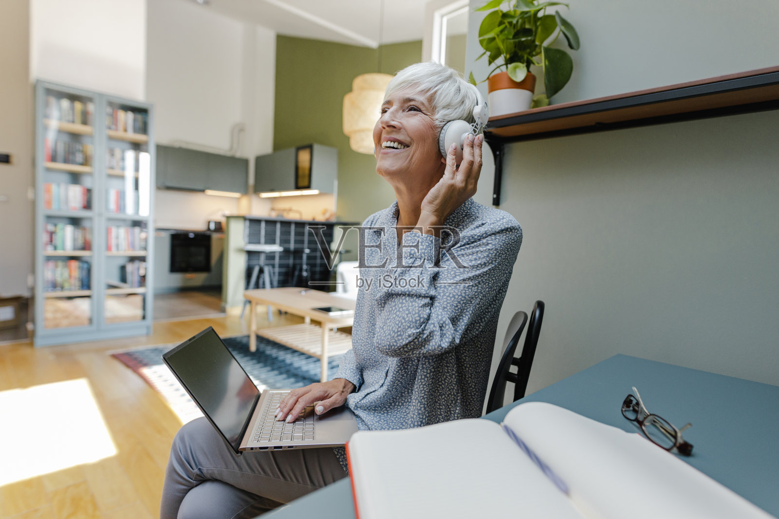 老年妇女享受音乐和放松在家里照片摄影图片