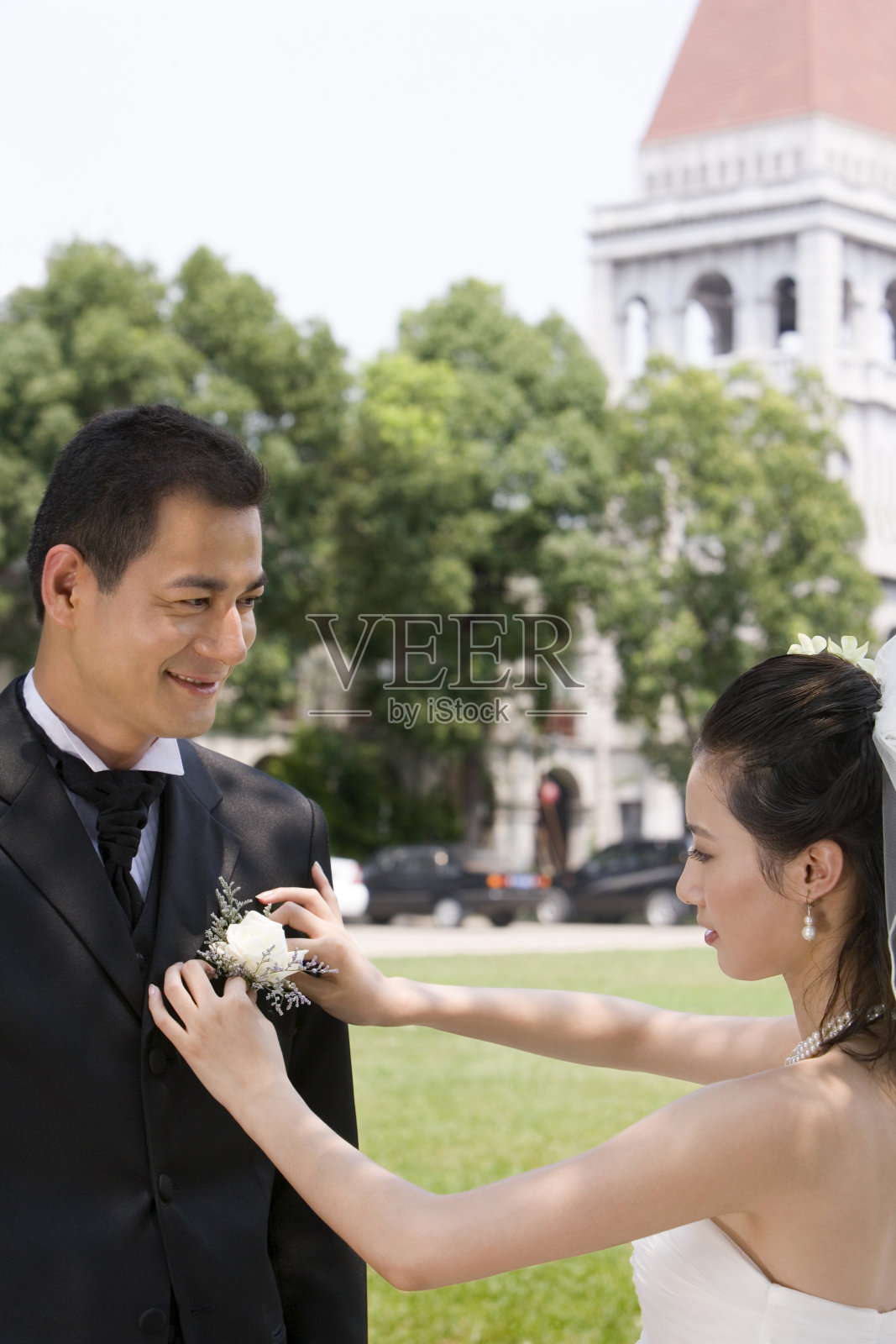 新娘给新郎代胸花照片摄影图片