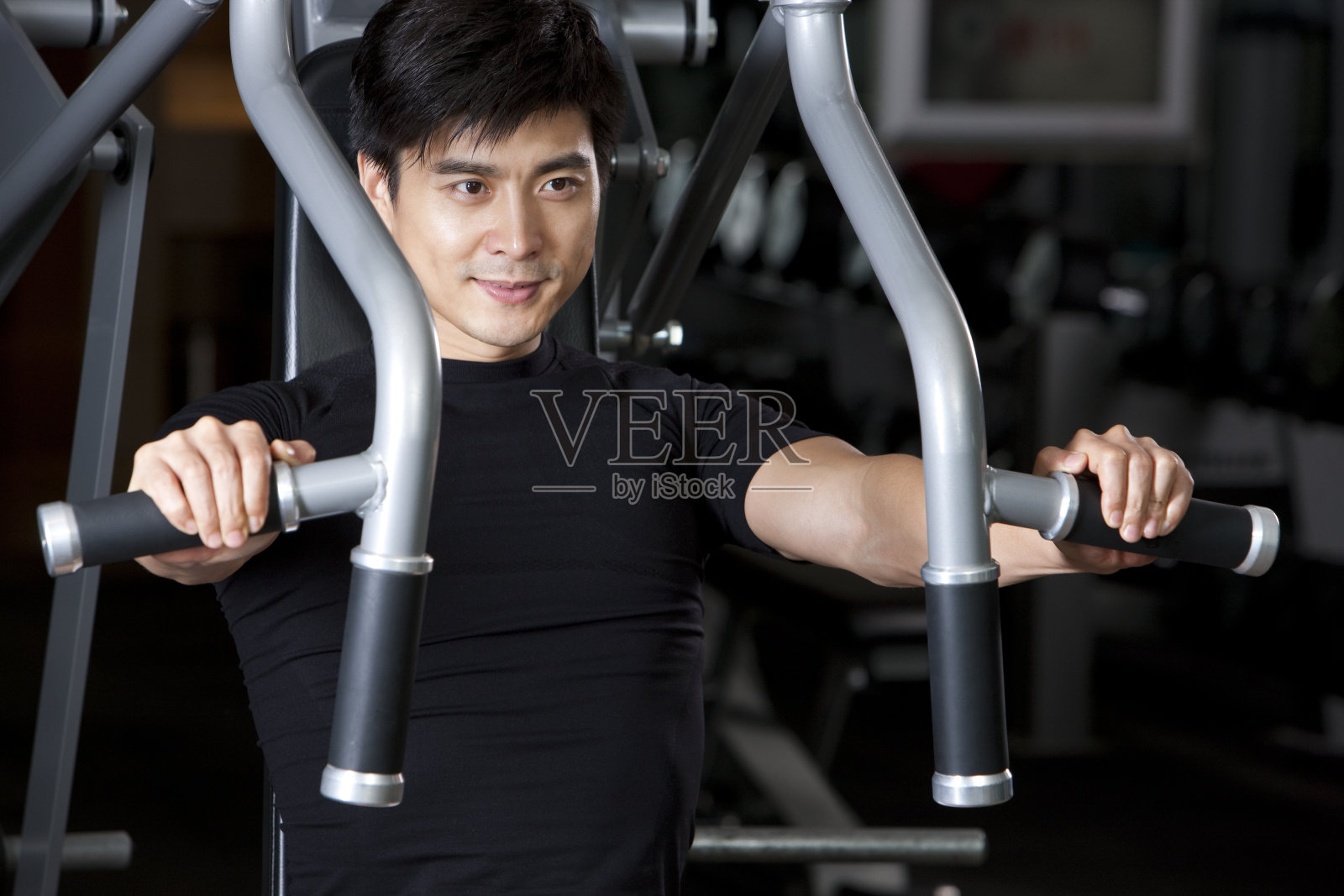 青年男子在健身馆健身照片摄影图片