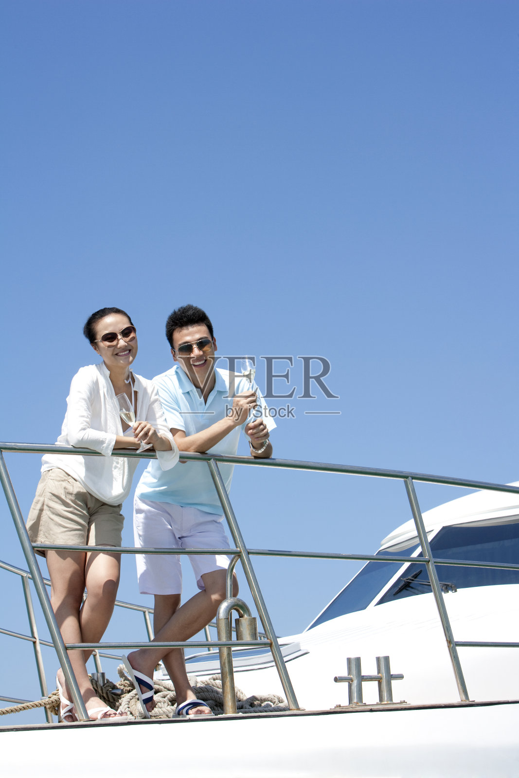 青年夫妇在游艇上喝香槟照片摄影图片