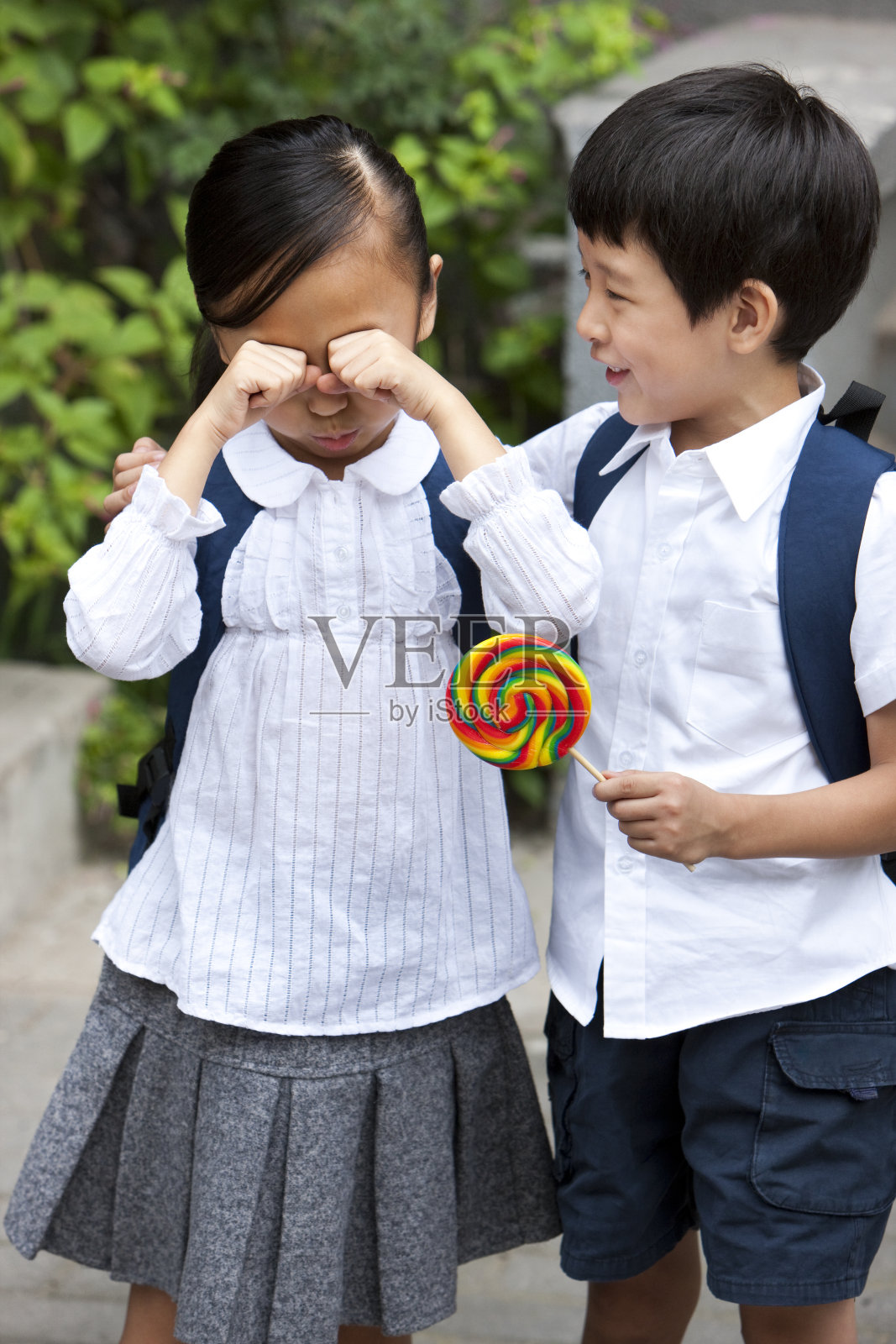 小男孩哄小女孩照片摄影图片