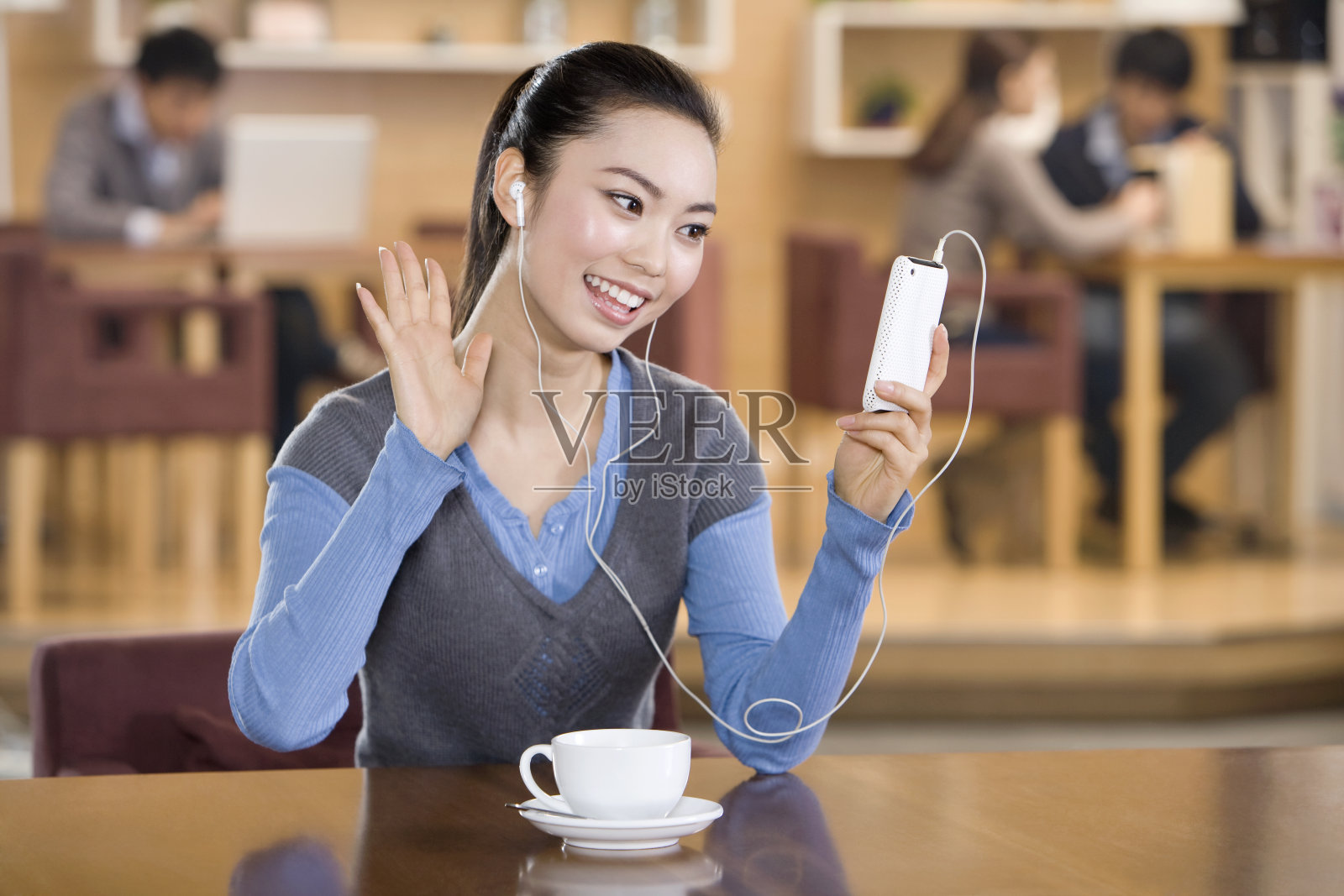 青年女子在书吧使用IPHONE照片摄影图片