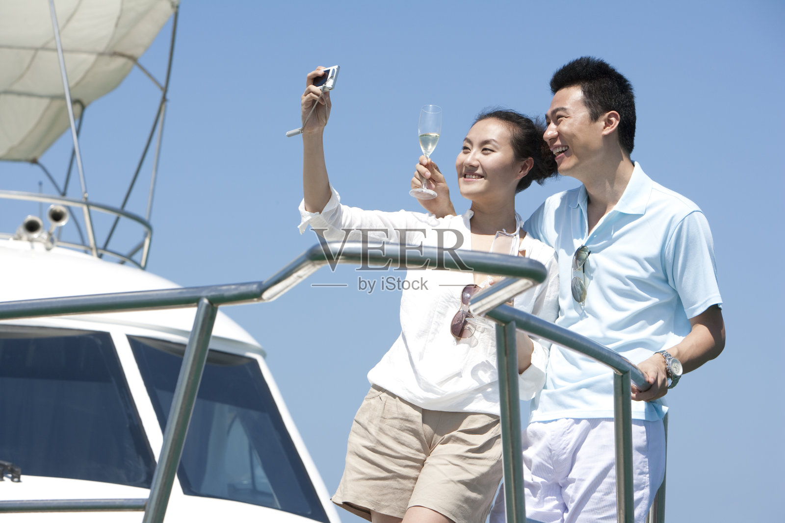 青年夫妇在游艇上拍照照片摄影图片