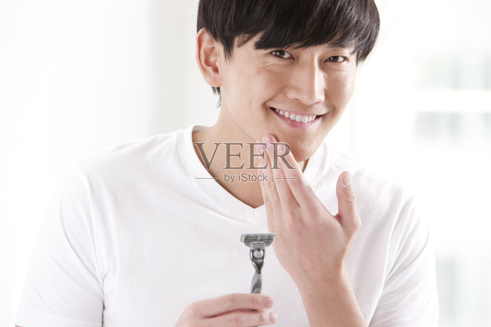 拿剃须刀的年轻男性照片摄影图片