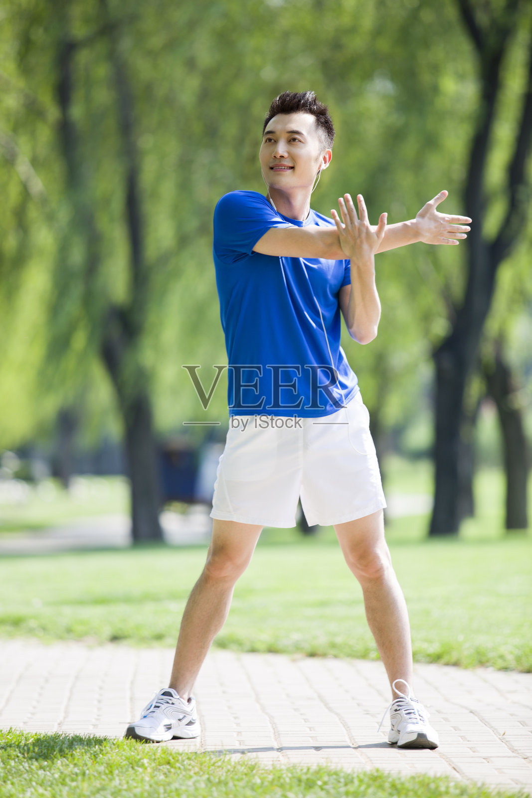 年轻男子在公园边听音乐边锻炼照片摄影图片